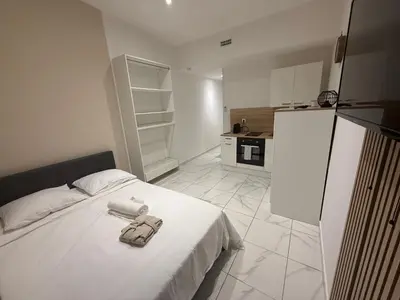 a bedroom with a white bed and a refrigerator at Bonpas Appart Hotels in Avignon