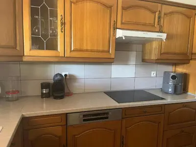 a kitchen with wooden cabinets and a counter top at Charming ground floor house with pool in Peyrolles-en-Provence