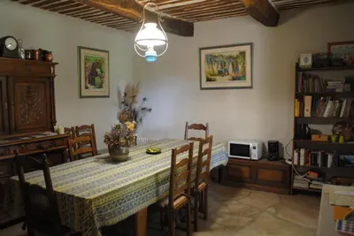 a dining room with a table with chairs and a microwave at Chambres d'Hôtes Istrane in Rustrel