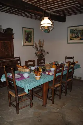 a dining room table with chairs and a table with food on it at Chambres d'Hôtes Istrane in Rustrel