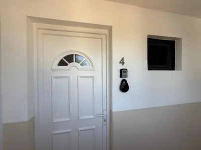 a white door with a window on a wall at Appart hotel bonpas in Noves