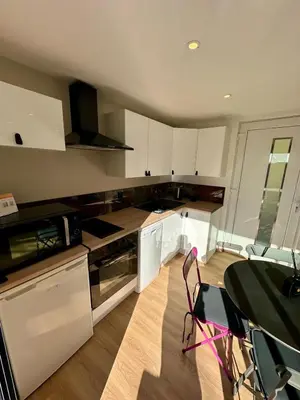 a kitchen with white cabinets and a table with chairs at Maison avec jaccuzzi Aix-en-Provence in Aix-en-Provence