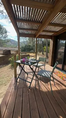 a table and a chair on a wooden deck at Cabane dans le Luberon - Bird in Provence in Cavaillon