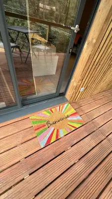 a door with a colorful welcome mat on a wooden floor at Cabane dans le Luberon - Bird in Provence in Cavaillon