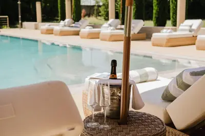 a table with a bottle of wine next to a pool at Château Saint Perret in Avignon