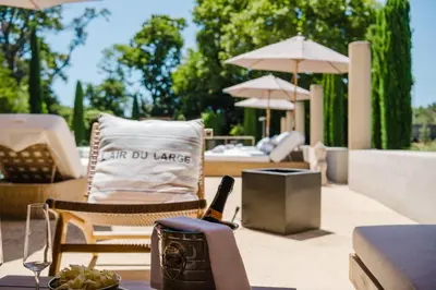 a patio with a table and chairs and umbrellas at Château Saint Perret in Avignon