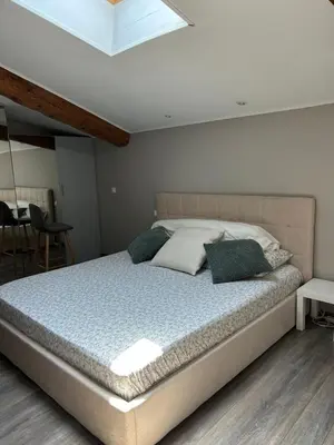 a bedroom with a large bed with pillows on it at Bel Appartement au 2 eme in Aix-en-Provence