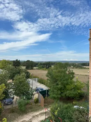 a view of a field with trees and a building at Bel Appartement au 2 eme in Aix-en-Provence