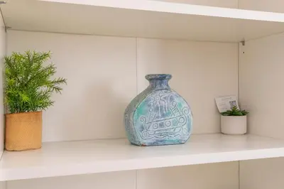 a blue vase sitting on a shelf with two plants at Central studio, perfect for discovering Aix on foot in Aix-en-Provence
