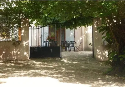 a gate to a patio with a table and chairs at Ferme au pied du luberon in Lourmarin