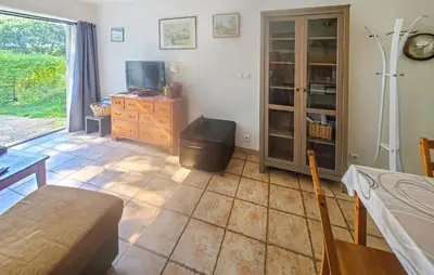 a living room with a tiled floor and a tv at Maison Avec Piscine in La Tour-dʼAigues