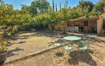 a patio with a table and chairs in a yard at Maison Avec Piscine in La Tour-dʼAigues