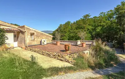 a garden in front of a stone house at Maison Avec Piscine in La Tour-dʼAigues