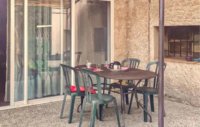 a wooden table and chairs on a patio at Maison Avec Piscine in La Tour-dʼAigues