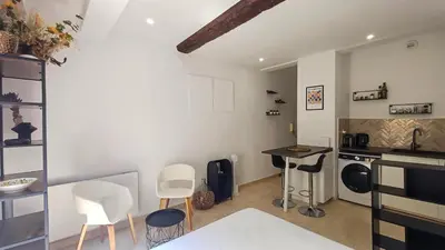 a kitchen with white chairs and a table and a counter at Le Calisson, magnifique studio plein centre d'Aix in Aix-en-Provence