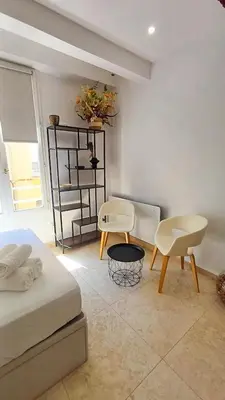 a bedroom with a bed and two chairs and a table at Le Calisson, magnifique studio plein centre d'Aix in Aix-en-Provence