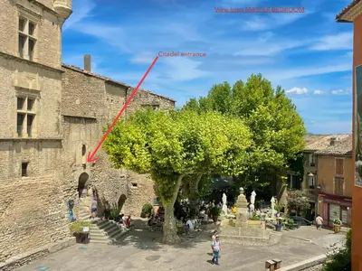 a building with a wooden door with a sign on it at Escapade en Provence Centre de Gordes in Gordes
