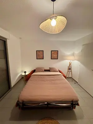 a bedroom with a large bed and a light at Terrasse, clim et piscine à Aix-en-Provence in Aix-en-Provence