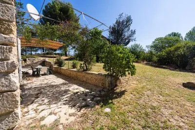 a garden with a stone wall and a tree at Mas Provençal au Cœur des Vignes du Luberon - 3 Chambres - Calme Absolu - Wifi in La Tour-dʼAigues