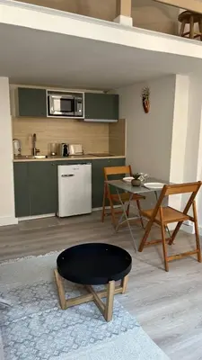 a living room with a table and a kitchen at Un cocon au cœur de Aix in Aix-en-Provence