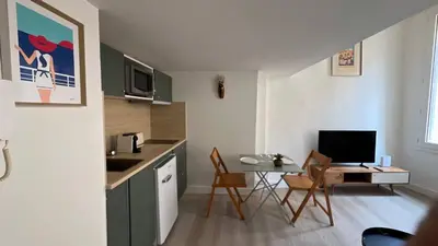 a small kitchen with a table and a desk with a computer at Un cocon au cœur de Aix in Aix-en-Provence