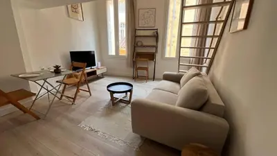 a living room with a couch and a table at Un cocon au cœur de Aix in Aix-en-Provence
