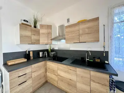 a kitchen with wooden cabinets and a sink at Villa Maguy - Piscine et jardin privée - Proche centre ville Aix en Provence - Parking - Boulodrome - Plancha in Aix-en-Provence