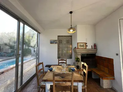 a dining room with a table and a fireplace at Villa Maguy - Piscine et jardin privée - Proche centre ville Aix en Provence - Parking - Boulodrome - Plancha in Aix-en-Provence