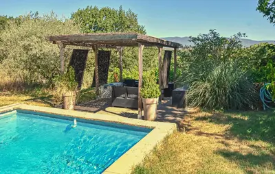 a swimming pool in a yard with a gazebo at Gîte Avec Piscine in La Tour-dʼAigues