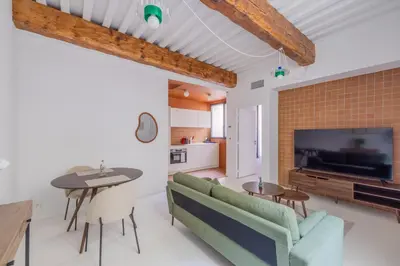 a living room with a couch and a table and a tv at Appartement Belle Lettre 7 in Aix-en-Provence