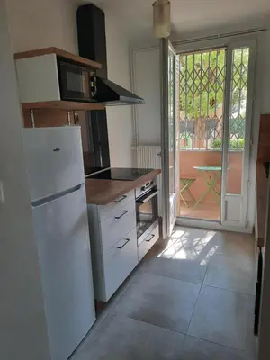 a kitchen with a white refrigerator and a window at Appartement Le Cézanne in Aix-en-Provence