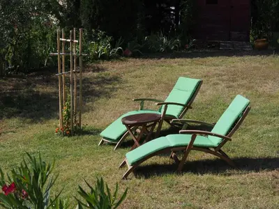 two green chairs and a table in a yard at Une Heure Bleue in Manosque
