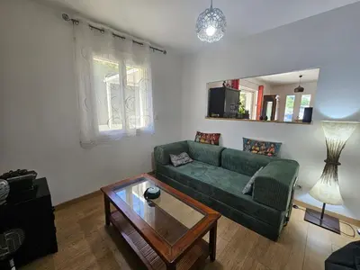 a living room with a green couch and a glass table at Villa sous les pins in Ventabren