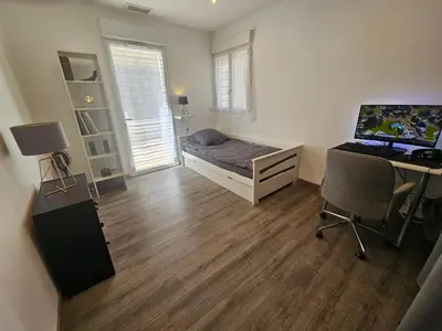 a bedroom with a bed and a desk with a computer at Villa sous les pins in Ventabren