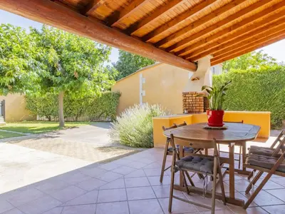 a patio with a table and chairs under a wooden pergola at Villa A l'Ombre du Soleil by Interhome in Monteux