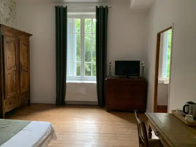 a bedroom with a bed and a dresser and a window at Château Sainte BARBE in Loriol-du-Comtat