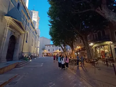 a group of people standing on a street at night at Villa Bulle de raisin in LʼIsle-sur-la-Sorgue