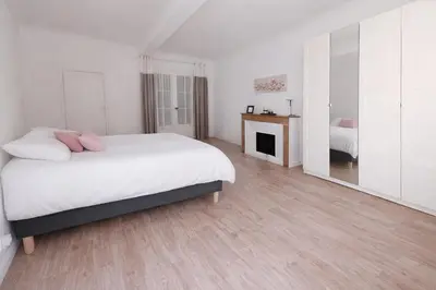 a white bedroom with a bed and a fireplace at T2 Centre historique d'Aix-en-Provence in Aix-en-Provence