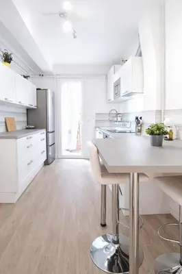 a kitchen with white cabinets and a table in it at T2 Centre historique d'Aix-en-Provence in Aix-en-Provence