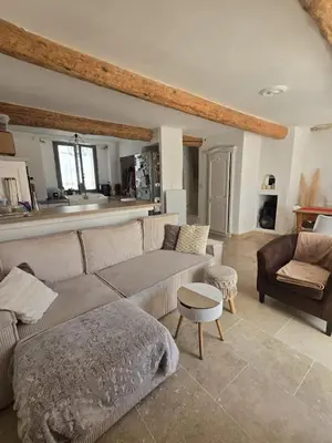 a living room with a couch and a table at Maison de village chaleureuse in Sainte-Tulle