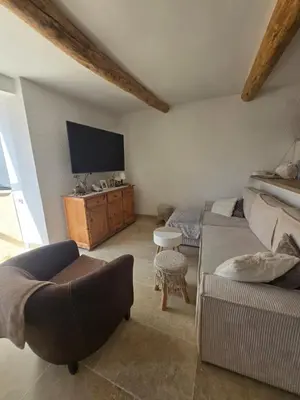a living room with a couch and a tv at Maison de village chaleureuse in Sainte-Tulle