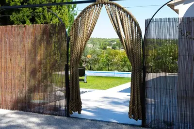a pair of gates with a view of a yard at Le Moulin in Aix-en-Provence