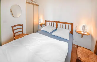 a bedroom with a large white bed with two pillows at Maison Avec Piscine in Villars