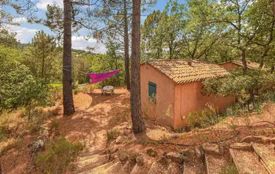 a pink kite is flying over a house in the woods at Maison Avec Piscine in Villars