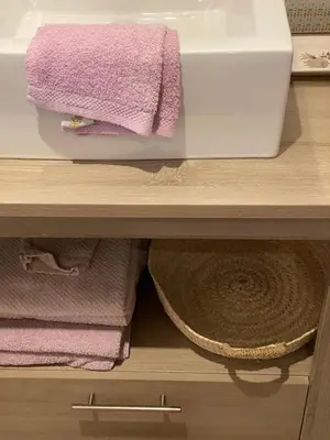 a bathroom cabinet with purple towels and a sink at Mas Coeur Provence Calme Beauté Grand Parc in Pernes-les-Fontaines
