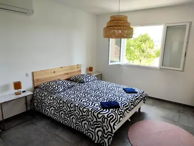 a bedroom with a black and white bed with a window at Le Picholine in Mazan