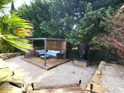 a garden with a gazebo with a couch and a statue at Pasca'land in Velaux