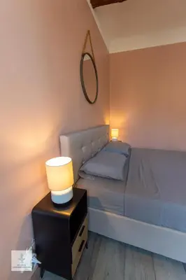 a bedroom with a bed with a lamp and a mirror at Maison des Chaudronniers in Aix-en-Provence