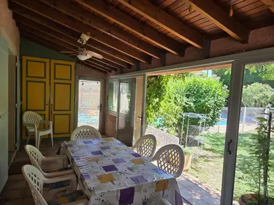 a dining room with a table and chairs on a patio at Villa avec piscine privée in Alleins