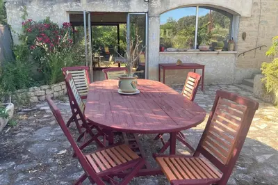 a wooden table with chairs and a vase on it at Villa Caromb - Mont Ventoux Garden - by TGB in Caromb